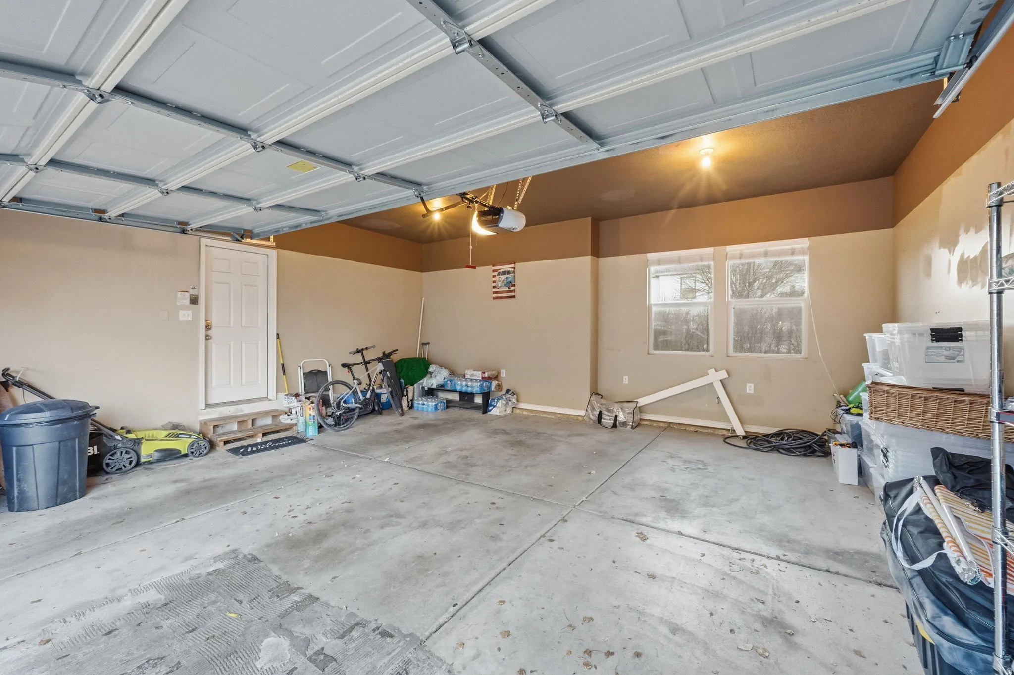Spacious garage featuring a concrete floor, overhead lighting, and an overhead garage door