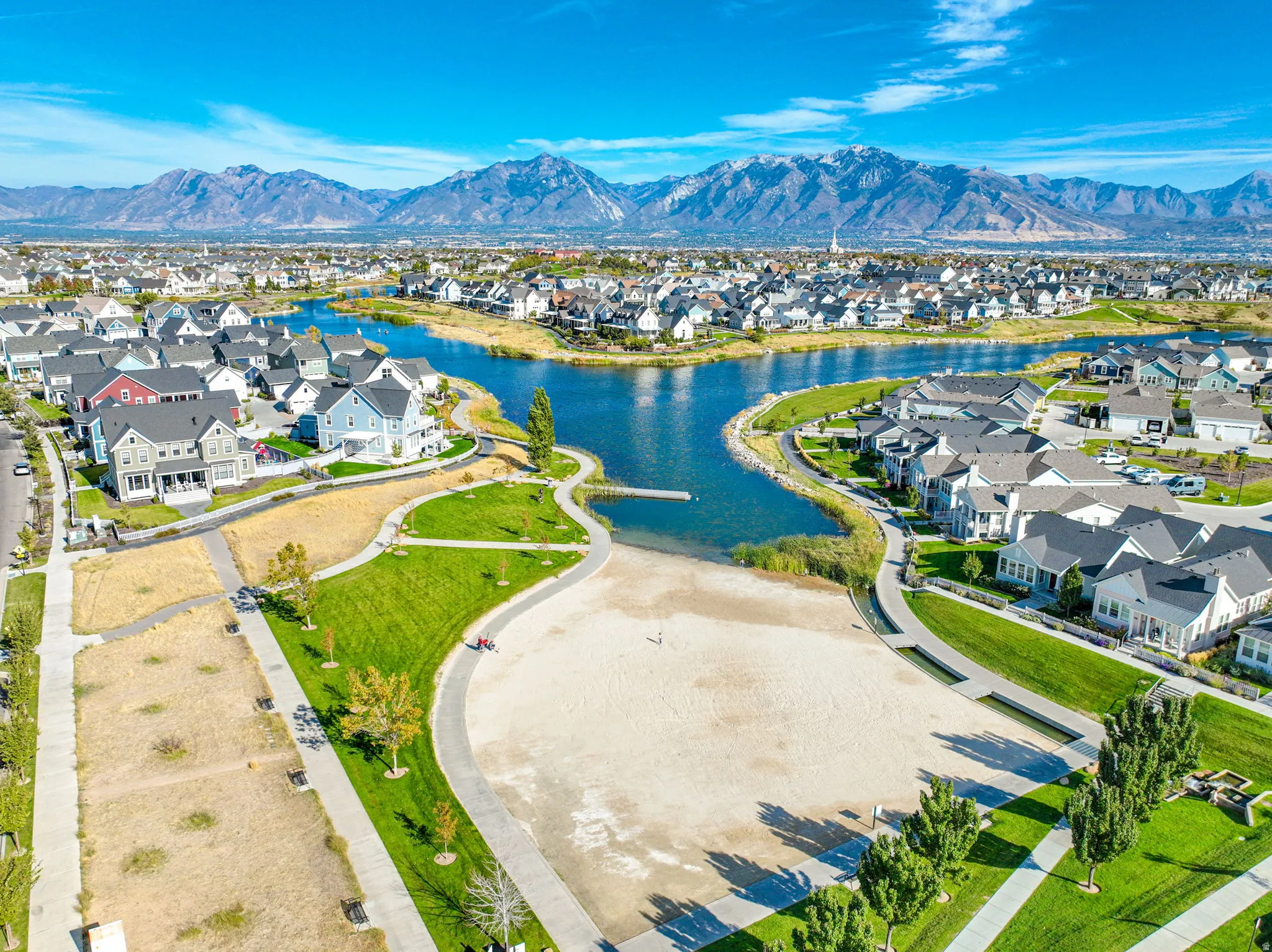 Aerial perspective showcasing a residential community with a large central pond