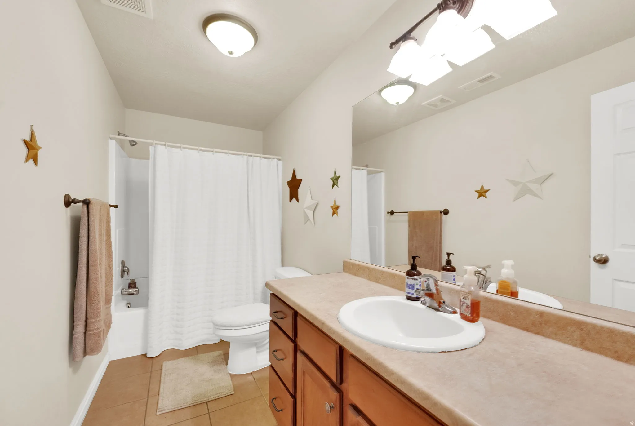 Full bathroom featuring a single vanity with a laminate countertop, an integrated sink, and a large wall-mounted mirror