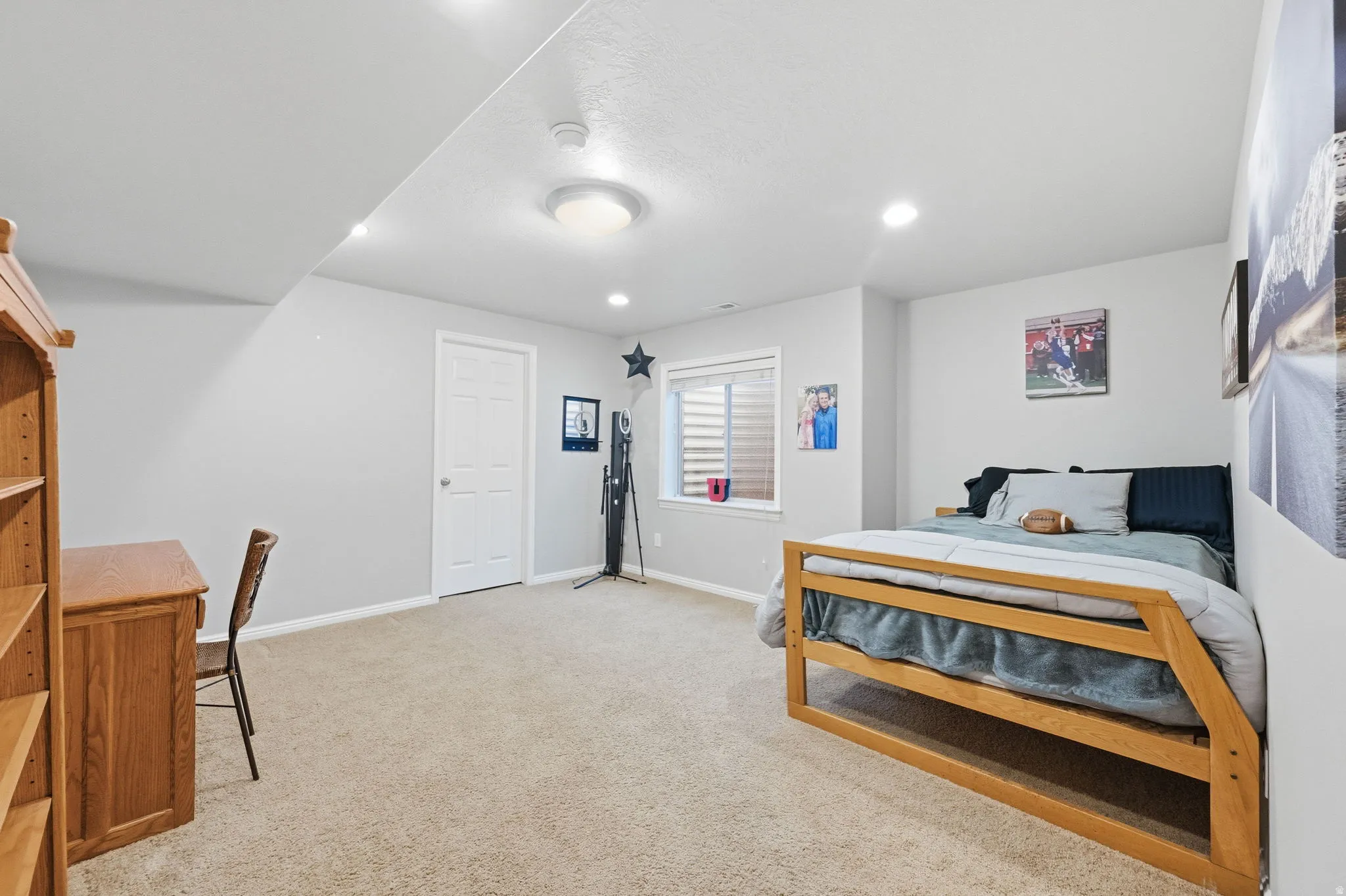 Carpeted room featuring light gray walls, a white paneled door, a single window with blinds, recessed lighting, and a flush mount ceiling light