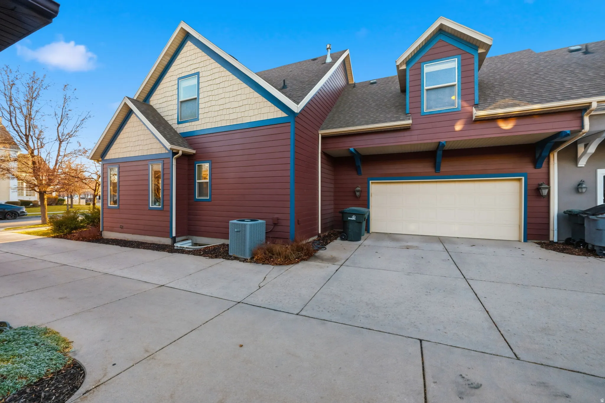 Exterior featuring red siding with cream shingles and blue trim accents