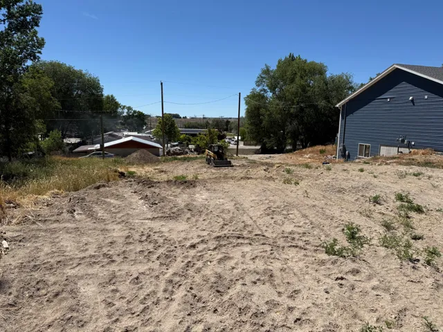 Graded earth lot with a partially cleared surface