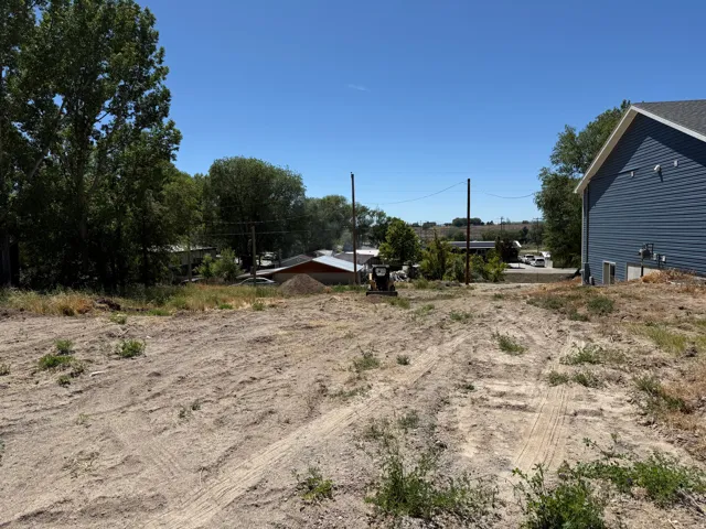 Expansive cleared lot with exposed earth and scattered natural vegetation