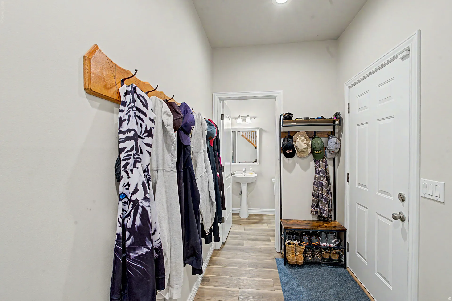 Entryway with wood-finish flooring, white paneled door, and neutral wall paint