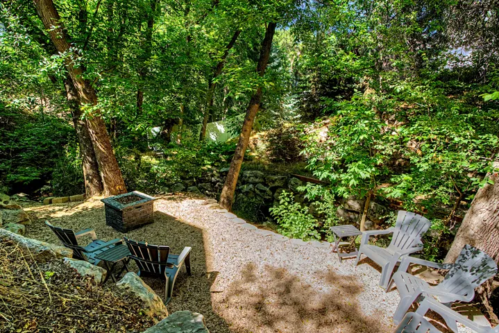 Terraced outdoor area featuring gravel ground cover and a stone fire pit