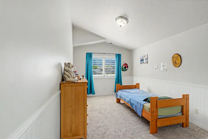 Room featuring neutral wall paint, white wainscoting, and carpeted flooring