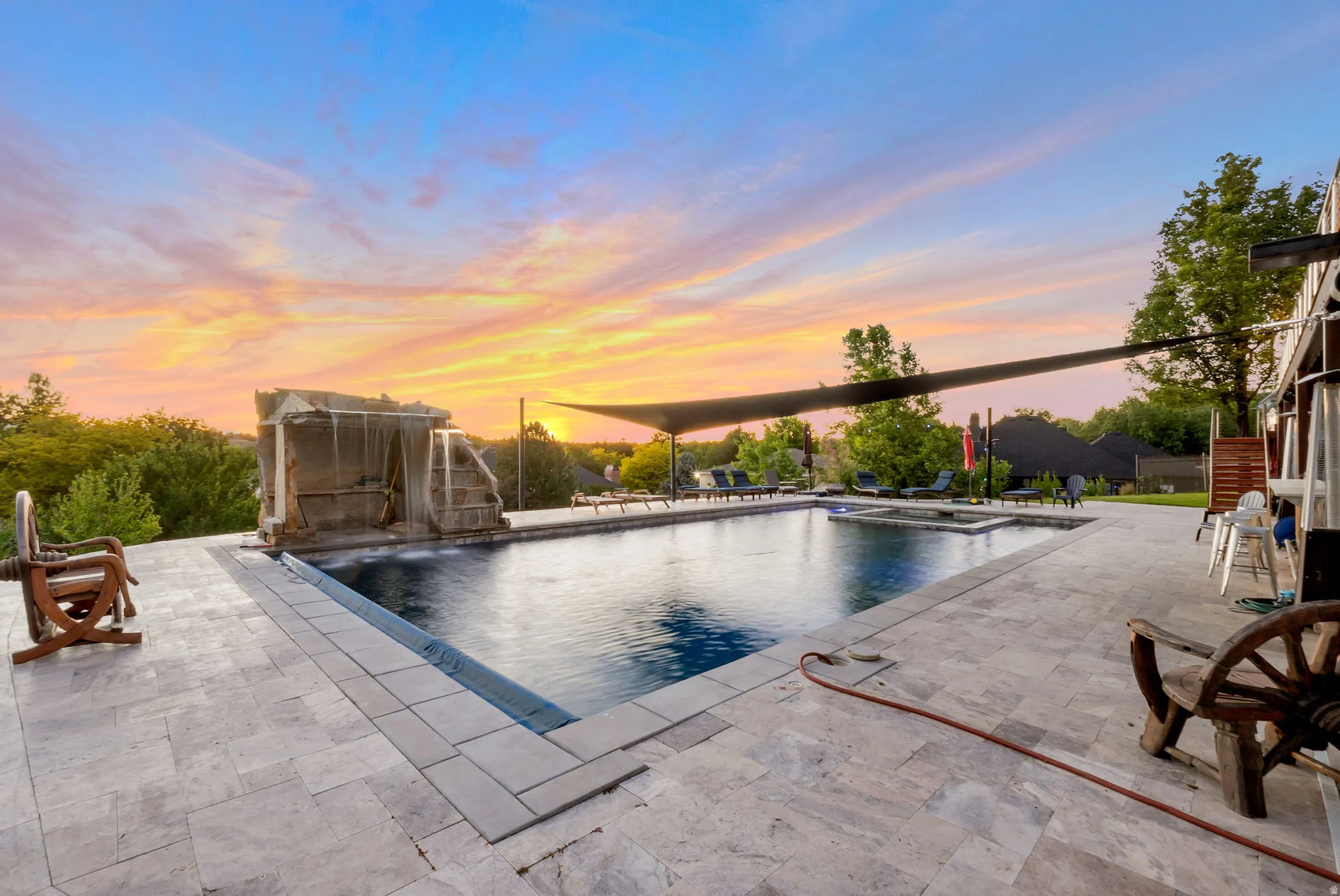 Expansive outdoor space featuring a HUGE 26' x 40 ' rectangular swimming pool with integrated spa and rock waterfall feature