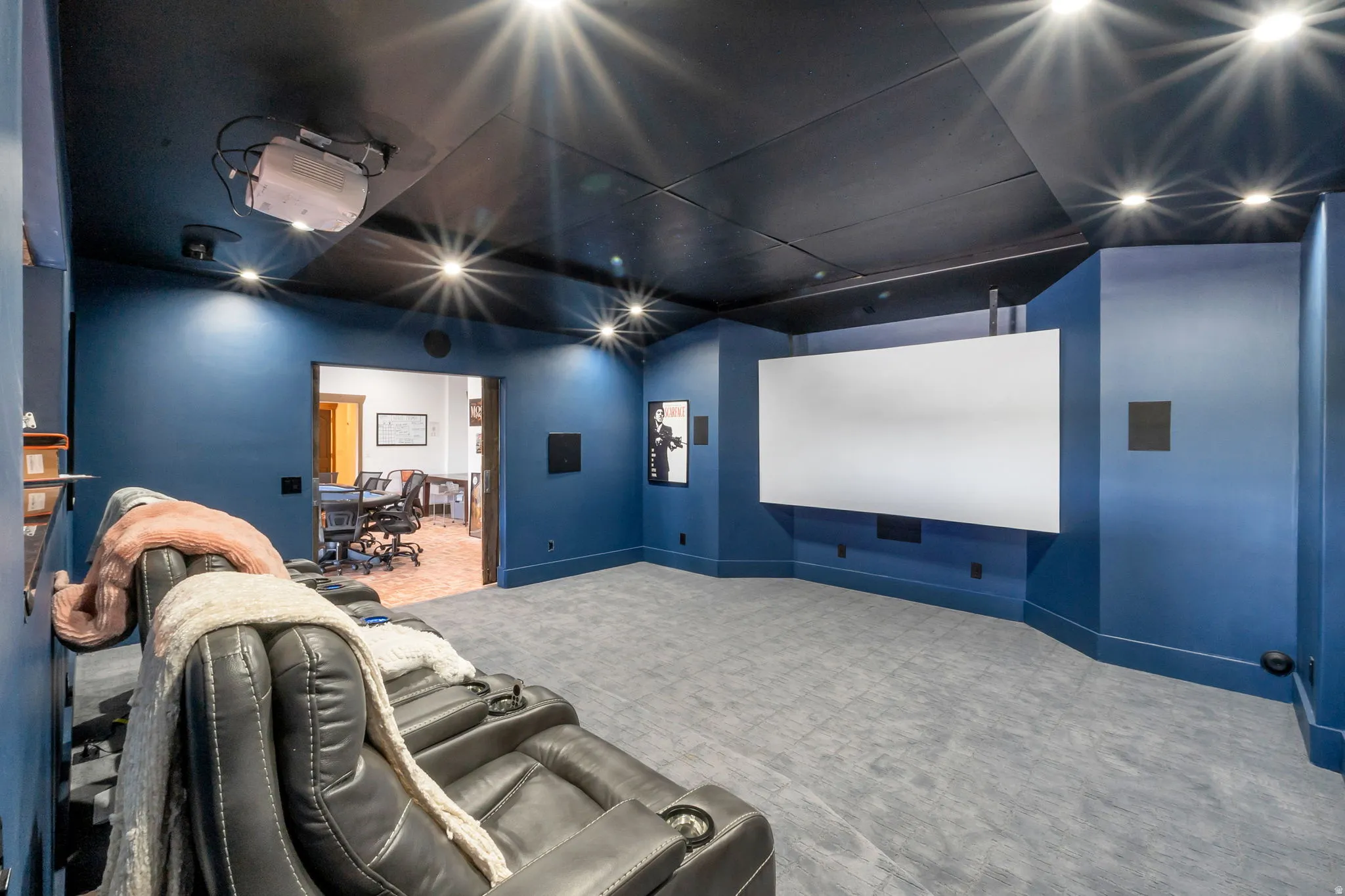 Dedicated media room featuring a large projection screen, built-in sound system, recessed lighting, and sound-absorbing ceiling panels