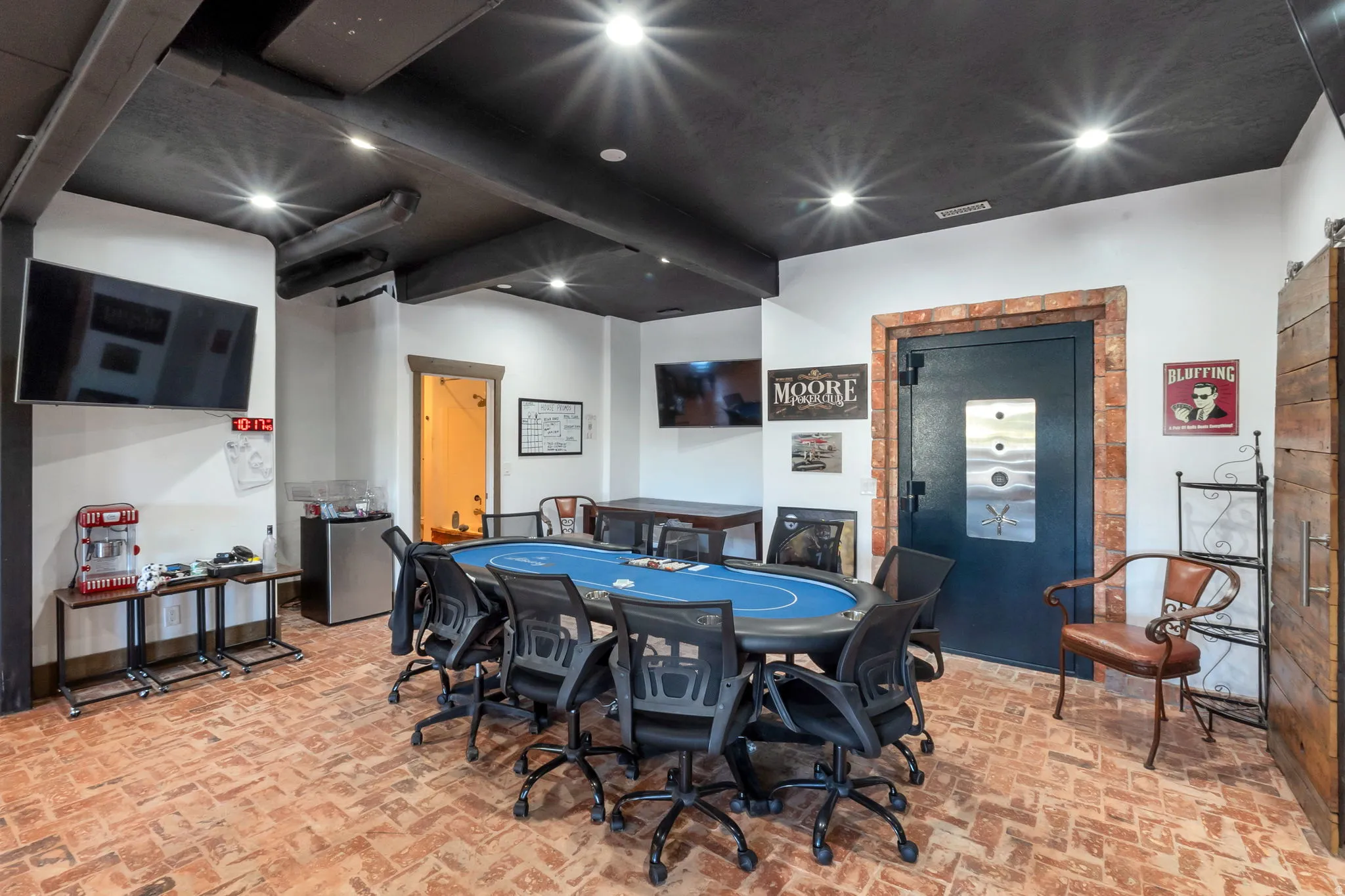 Herringbone brick flooring with a dark-painted exposed beam ceiling and recessed lighting