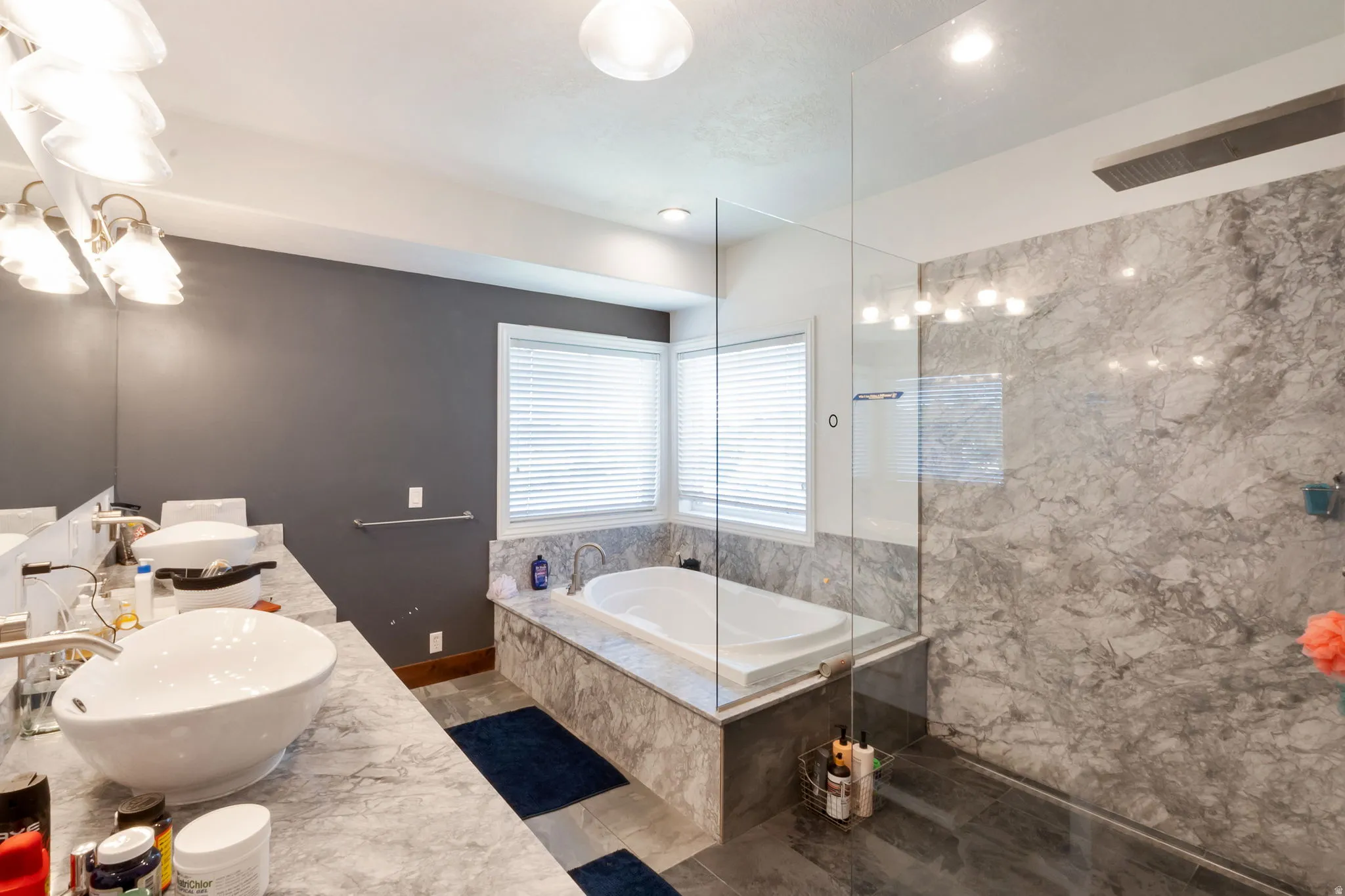 Master Bathroom featuring a frameless glass shower enclosure, a built-in soaking tub, and a dual vanity with vessel sinks