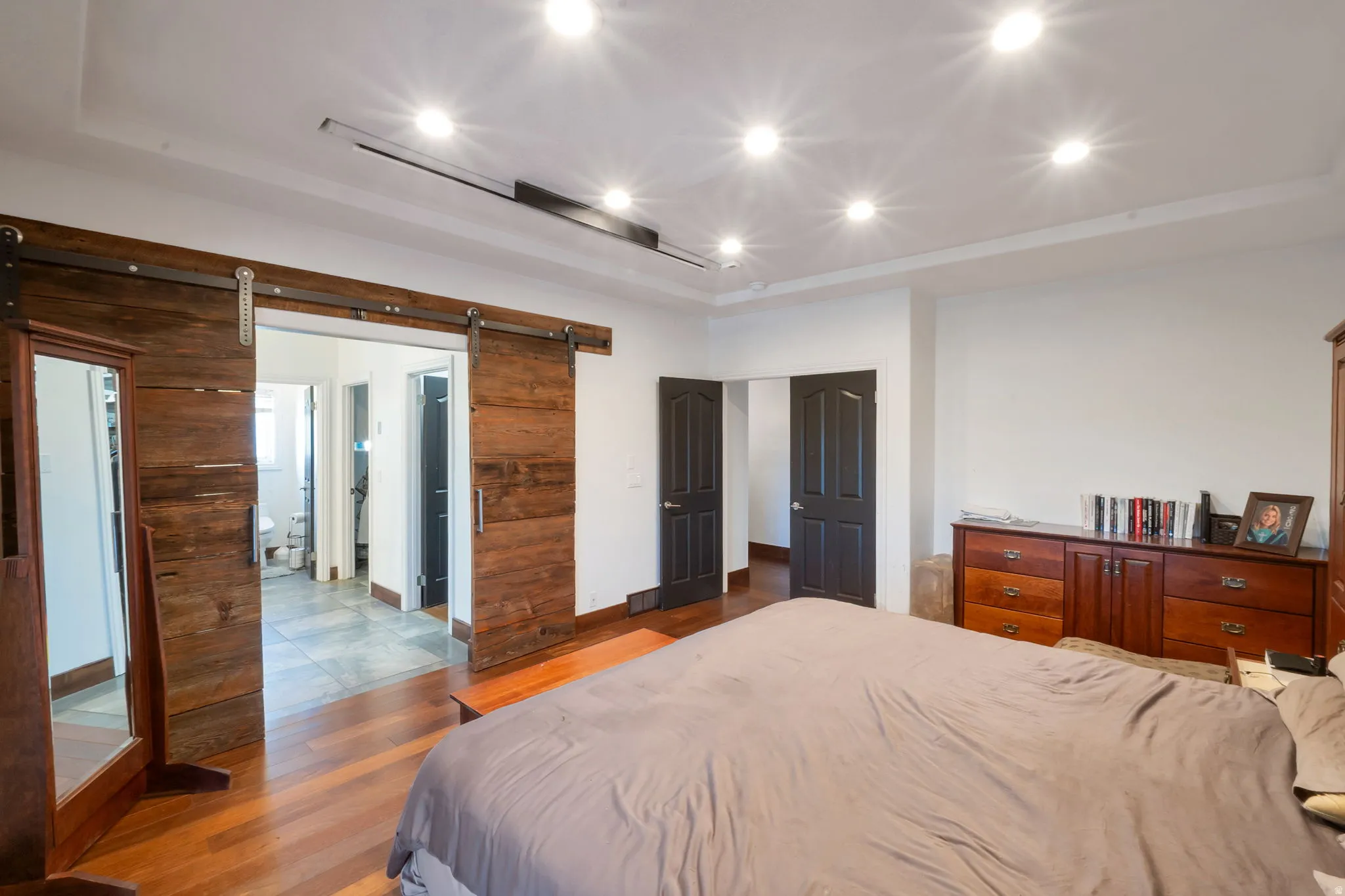 Reclaimed wood barn doors on a metal track system, leads into the master bath. with dual walk in closets.