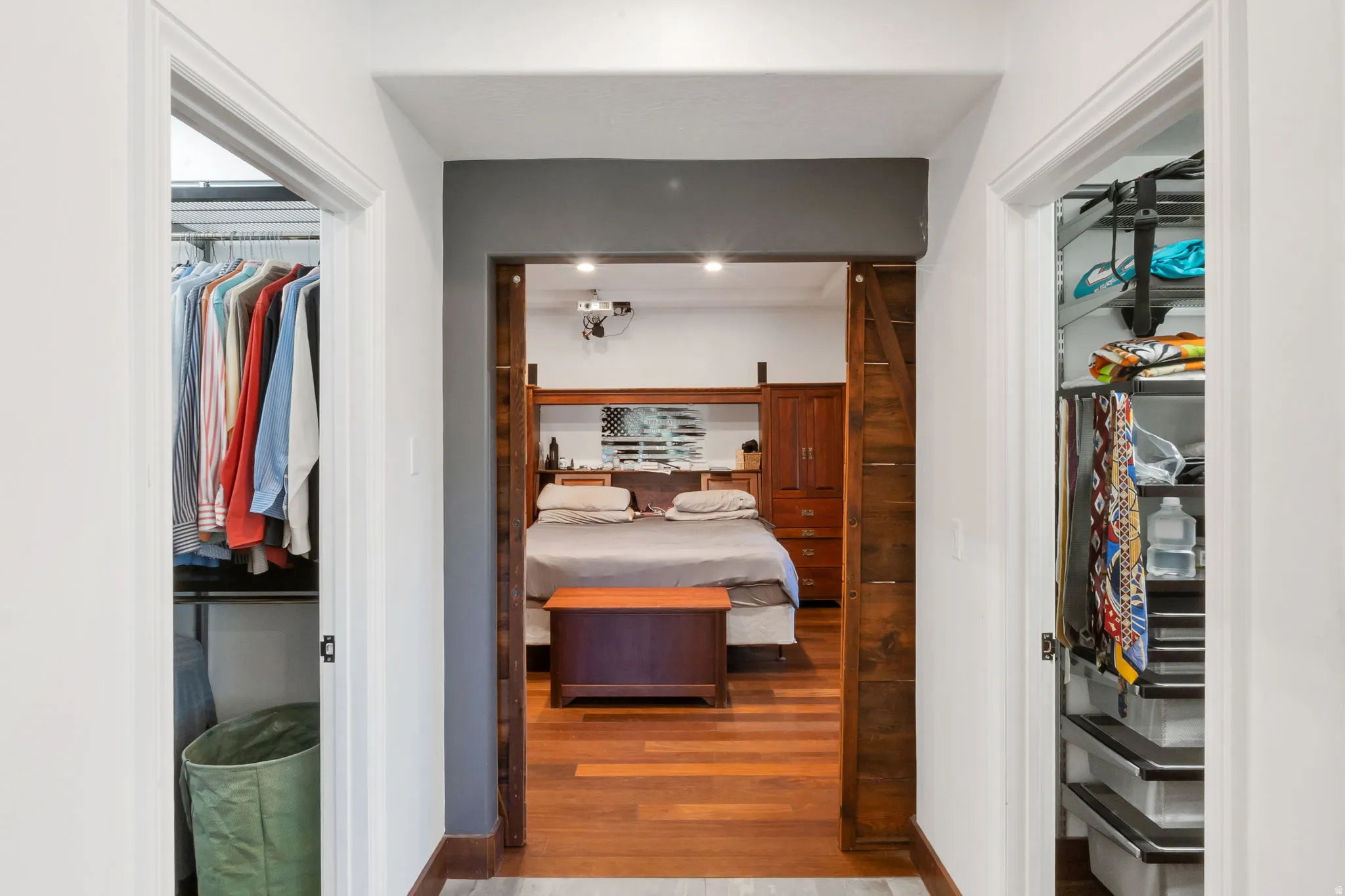 Bedroom featuring wood-finish flooring, recessed lighting, leads to dual walk in closets.