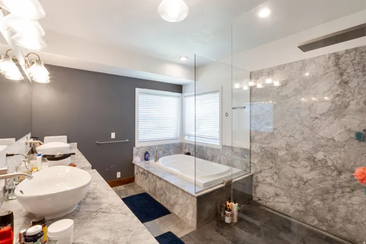 Master Bathroom featuring a frameless glass shower enclosure, a built-in soaking tub, and a dual vanity with vessel sinks