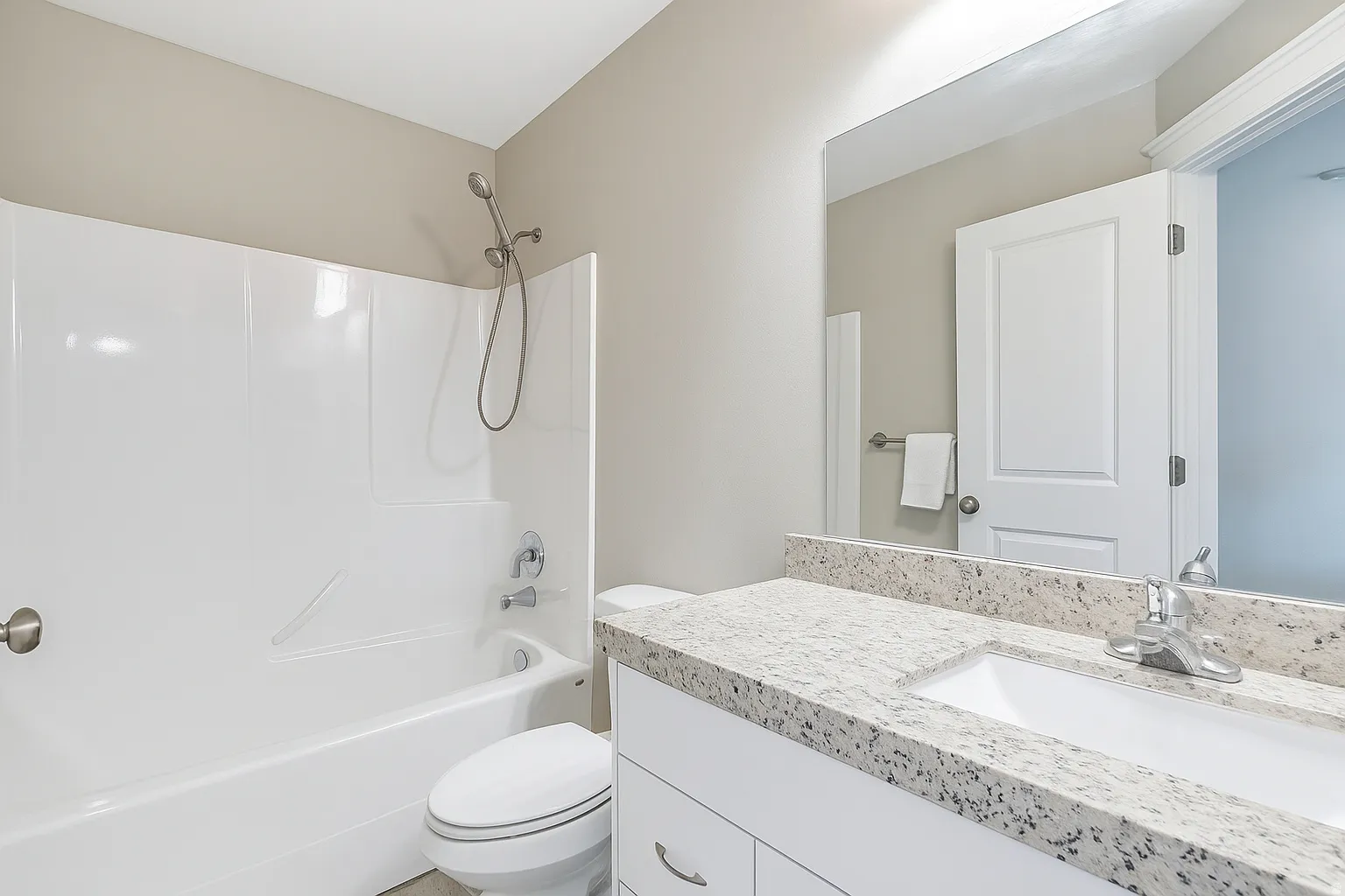 Bathroom featuring a white tub and shower combination with a handheld showerhead