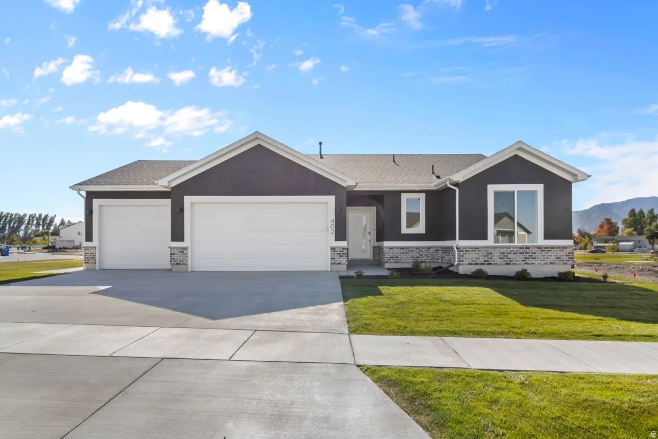 Contemporary single-story exterior featuring a dark gray facade with white trim accents and stone veneer detailing