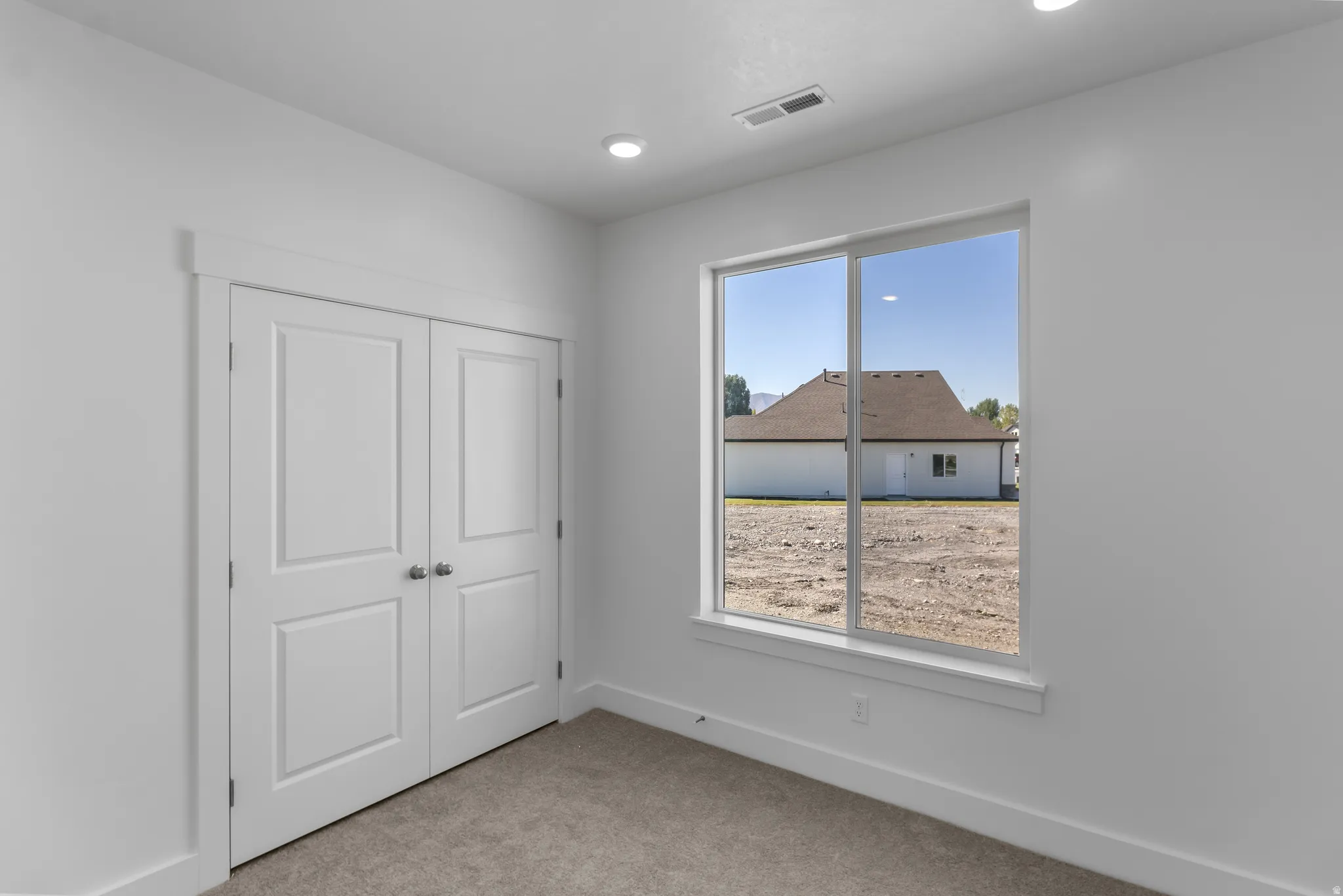 Interior space featuring a large window, recessed lighting, double panel doors, baseboard molding, and wall-to-wall carpeting