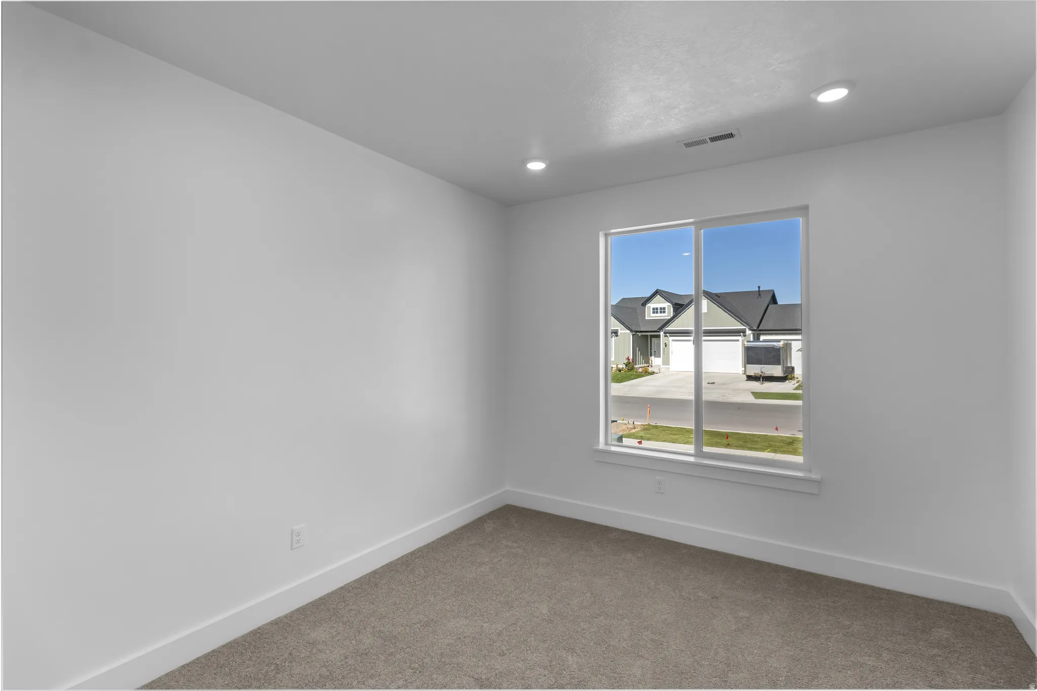 Interior space with a large window, recessed lighting, and light gray carpet