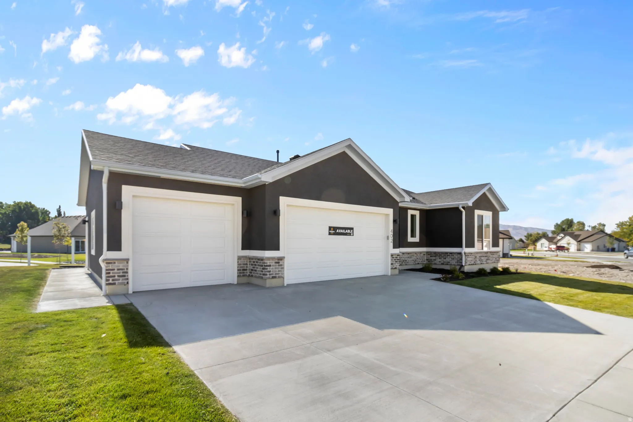 Contemporary exterior featuring dark siding, white trim, and stone accents