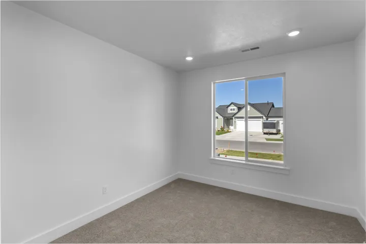 Interior space with a large window, recessed lighting, and light gray carpet