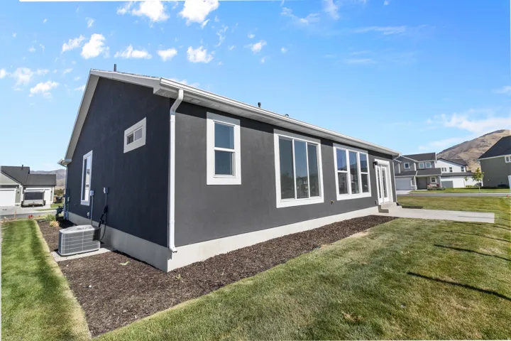 Contemporary single-story residence with dark stucco siding and white trim