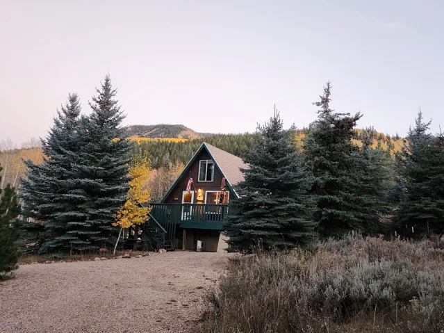 A-frame residence with a dark brown exterior and a dark green deck