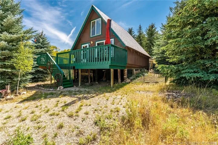 A-frame residence featuring a brown exterior siding and a grey shingled roof