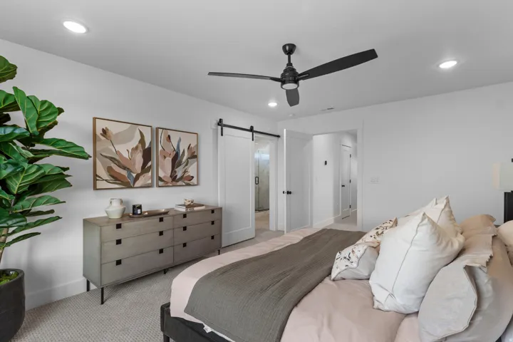 Spacious bedroom featuring recessed lighting, a modern ceiling fan, and light-colored carpeting
