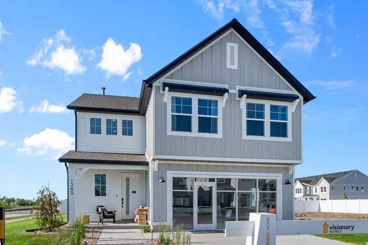 Contemporary two-story residence featuring light gray vertical siding and white horizontal siding accents