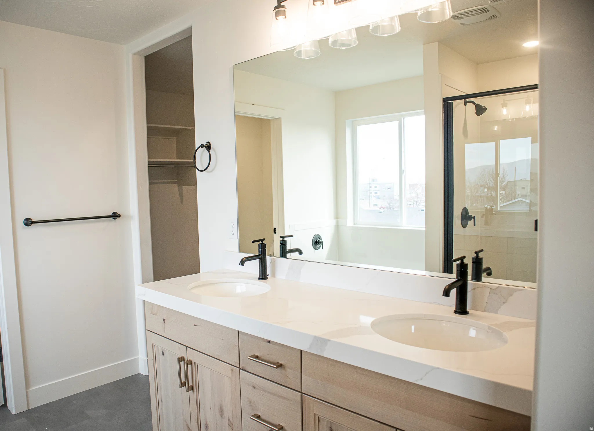 Primary bathroom with a double vanity, separate tub and shower, and quartz counters