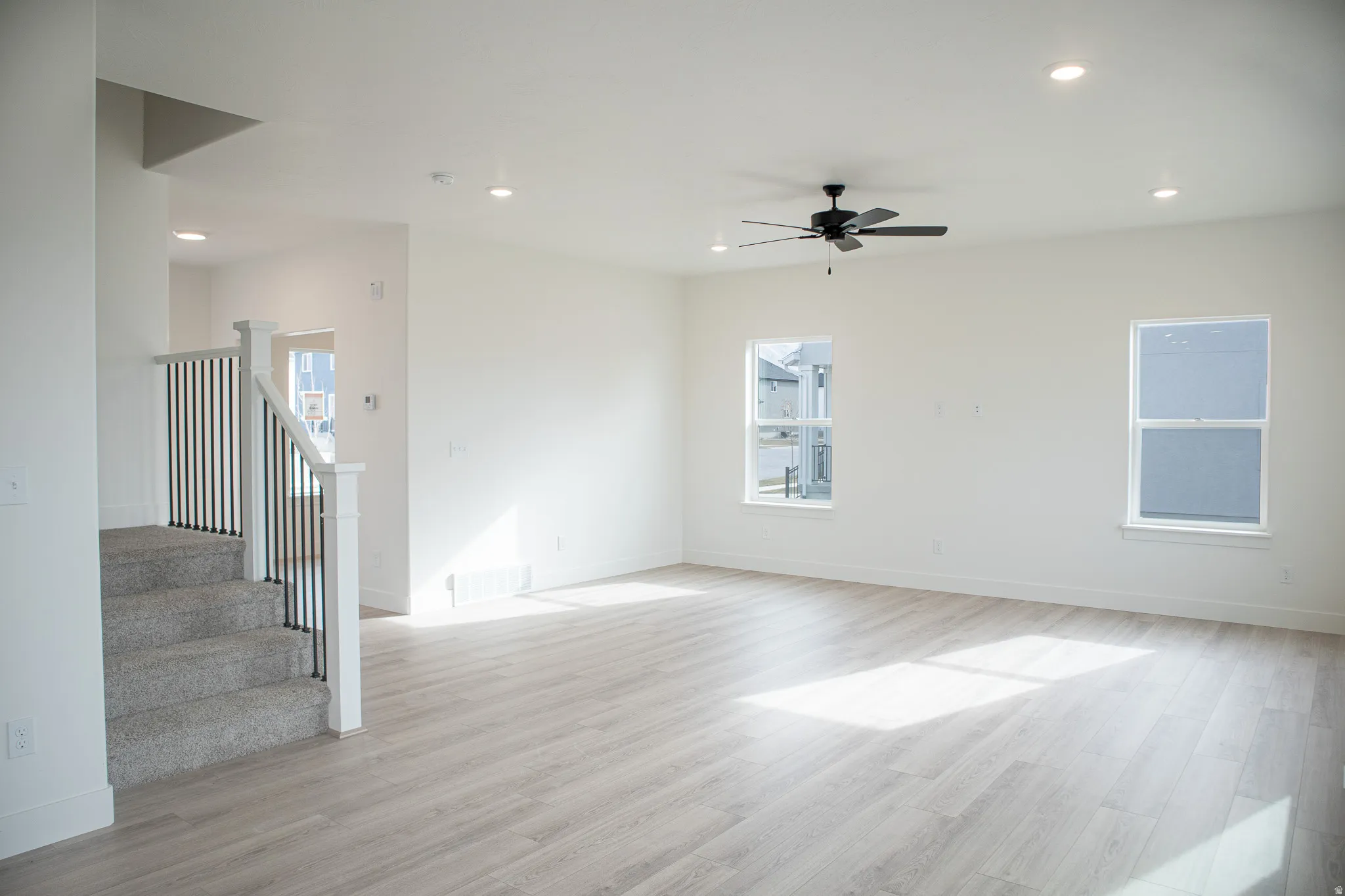 Large family room with ceiling fan, recessed lighting, and wood laminate flooring
