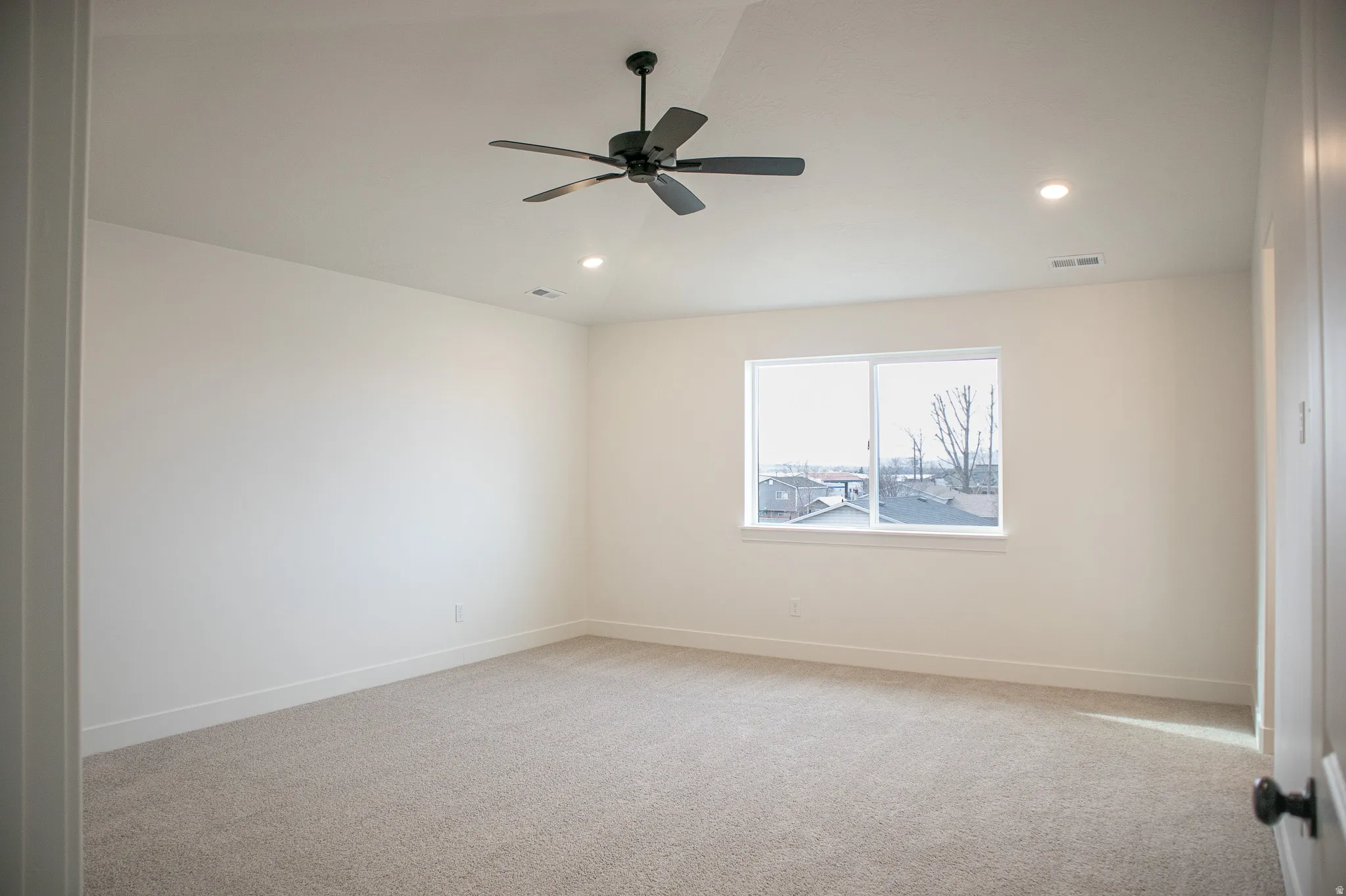 Primary bedroom with vaulted ceilings, recessed lighting, and a ceiling fan