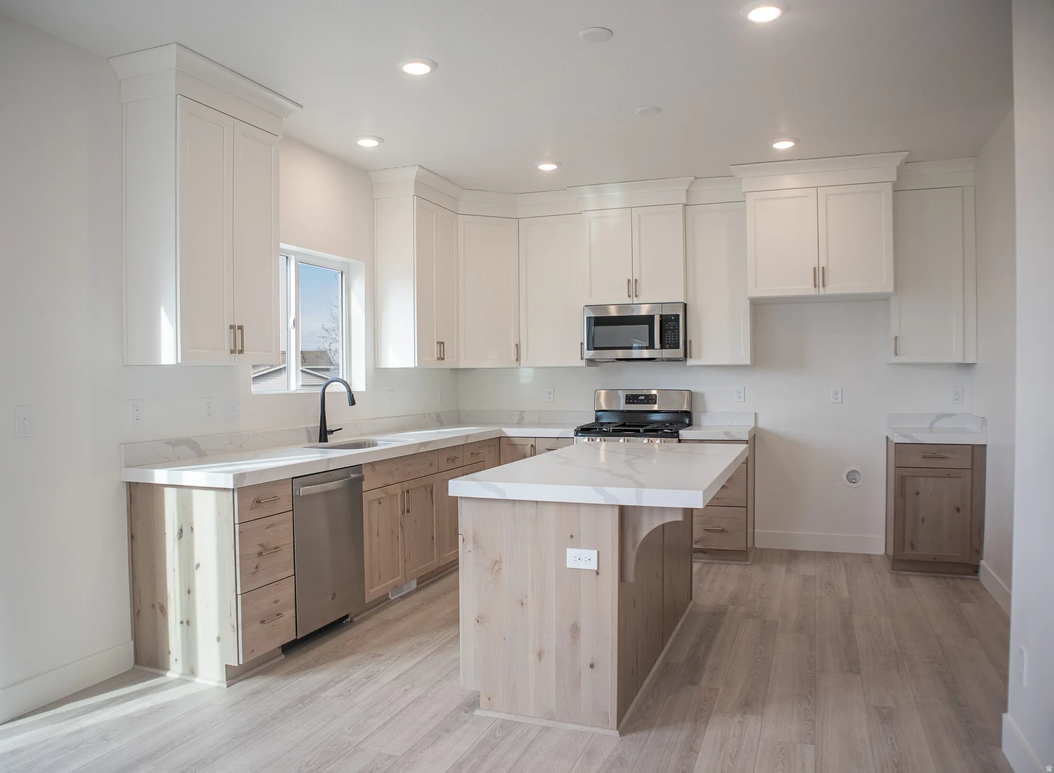 Spacious kitchen with quartz counters, full height cabinets, and stainless steel appliances