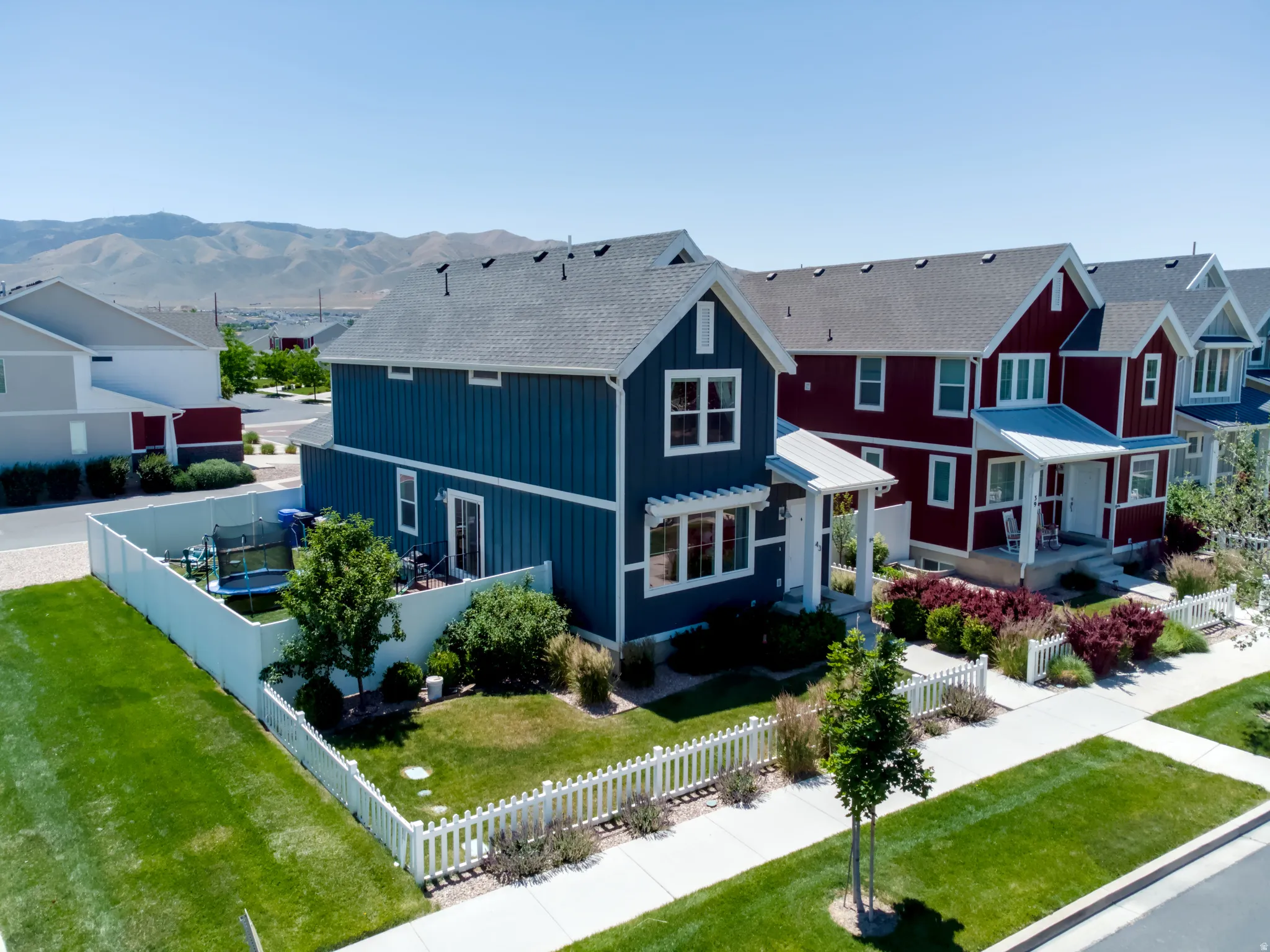 Two-story residence featuring a blue vertical siding exterior with white trim and a dark shingle roof