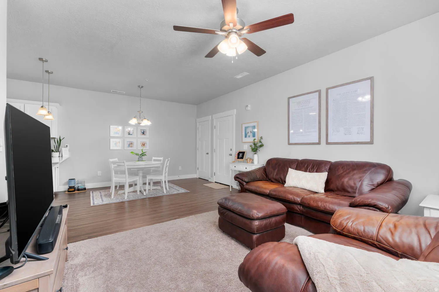 Living room with neutral wall paint, overhead ceiling fan, and carpeted flooring