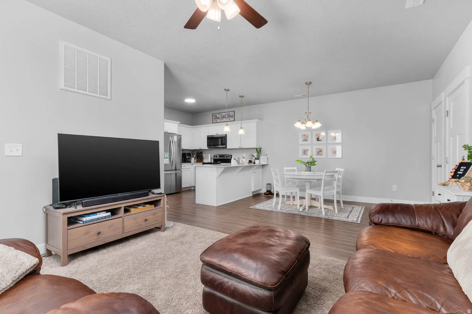 Open-concept living area featuring wood-finish flooring, light gray wall tones, and recessed lighting