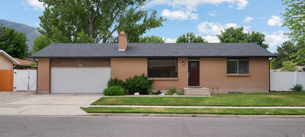 Brick exterior with a dark roof and an attached garage
