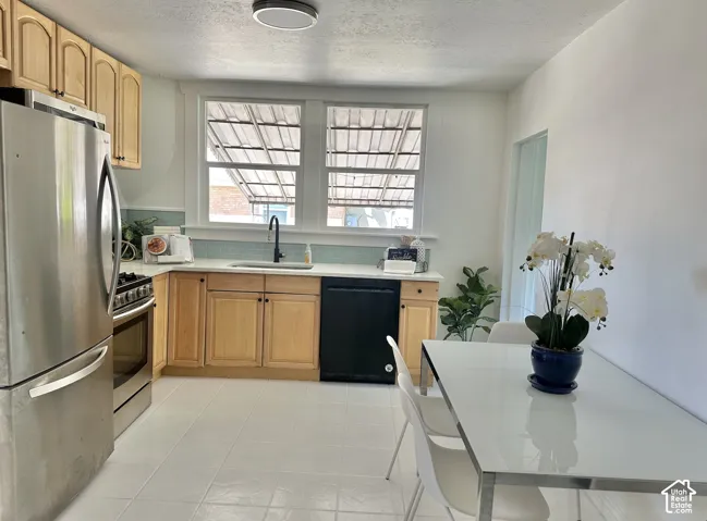 Kitchen featuring light wood cabinetry, light countertops, and a tiled backsplash