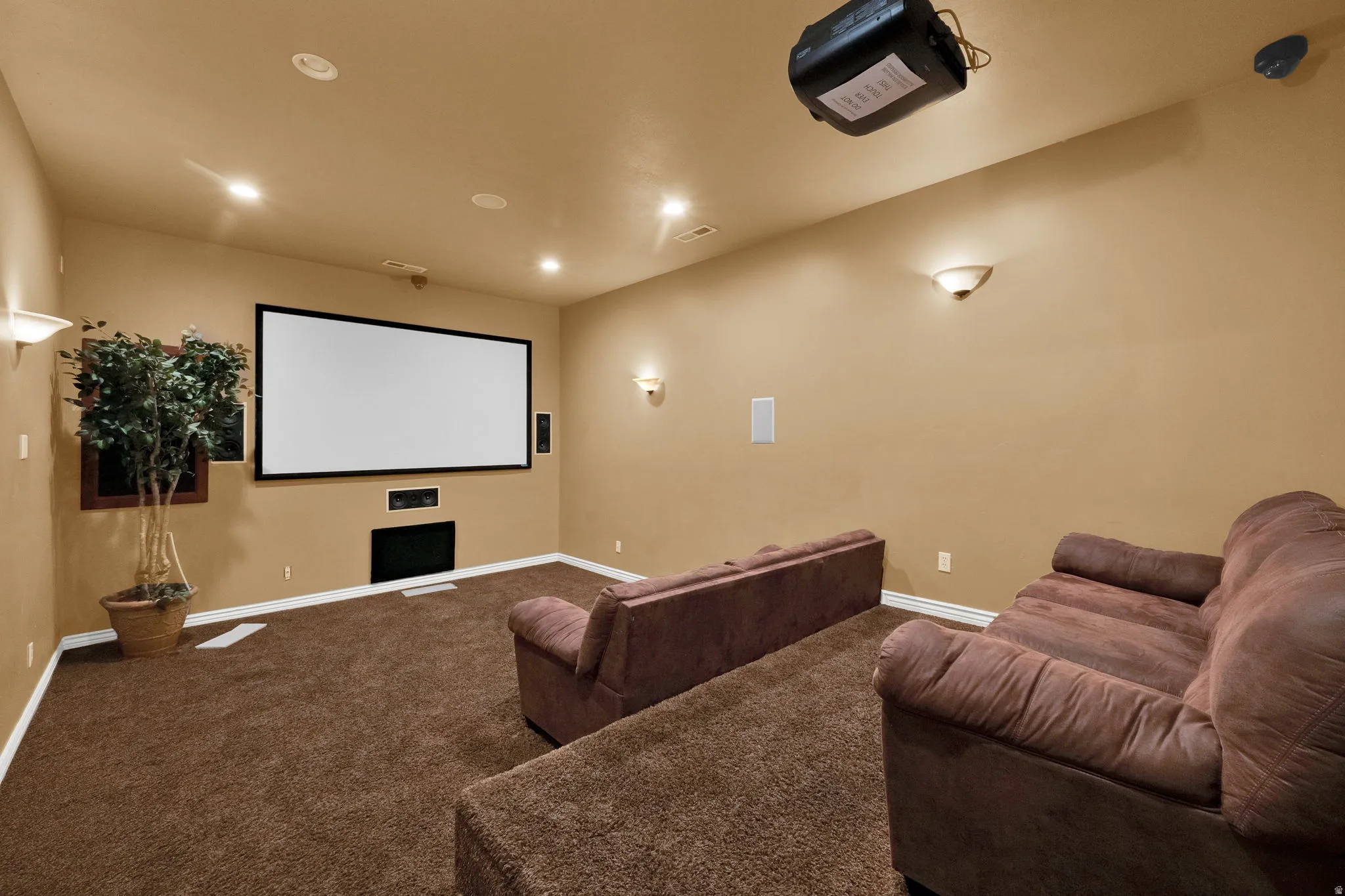 Dedicated media room featuring a large projection screen and ceiling-mounted projector