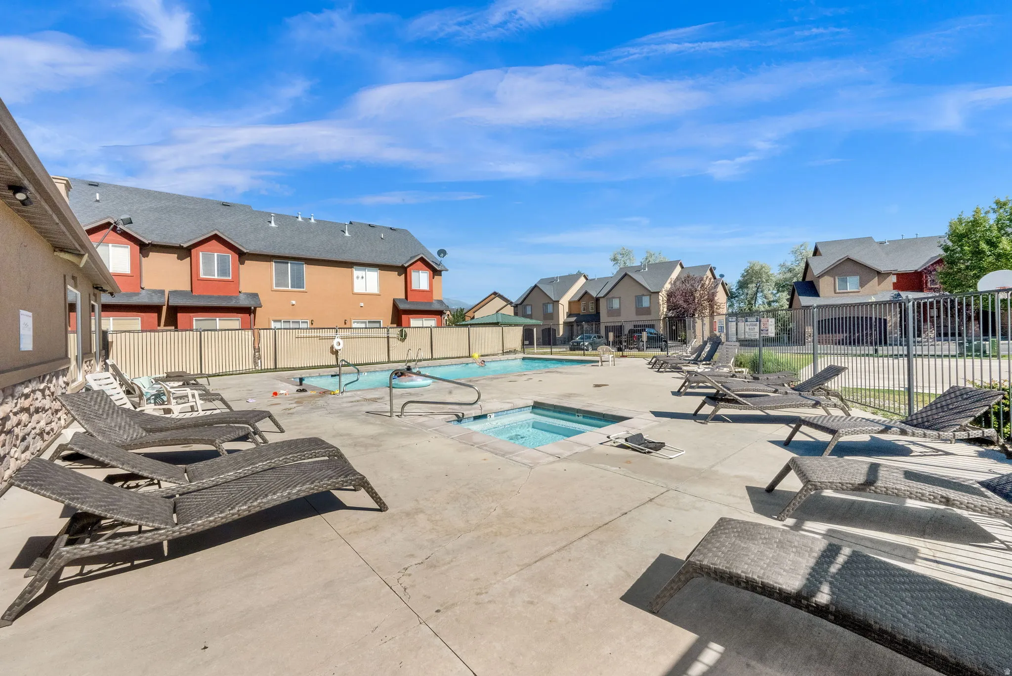 Club House-Community swimming pool with an hot tub, surrounded by a concrete deck and a black metal fence