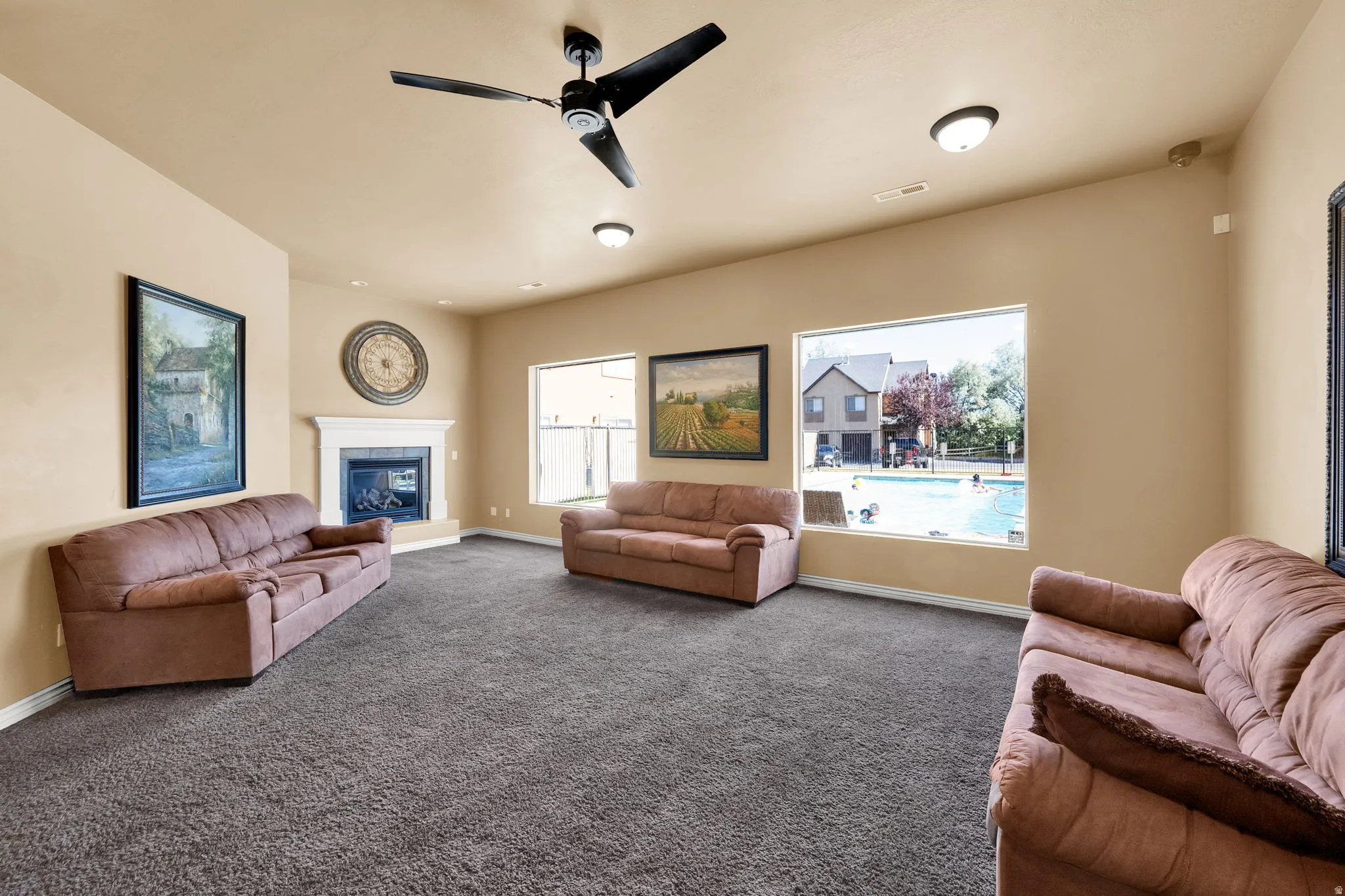 Club House-Spacious room featuring carpeting, a corner fireplace with a white mantel, and multiple windows offering external views