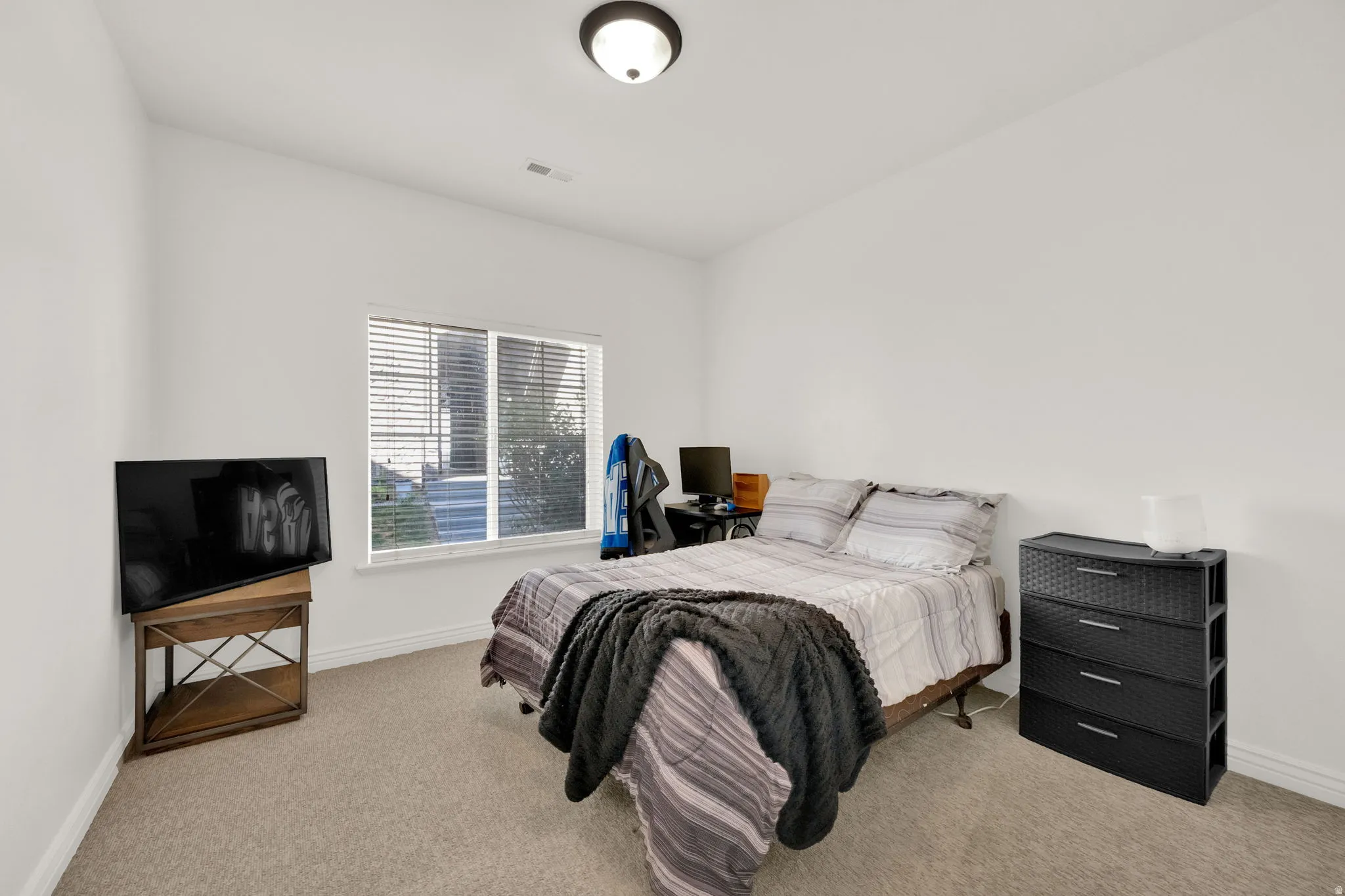 Carpeted room with a ceiling-mounted light fixture