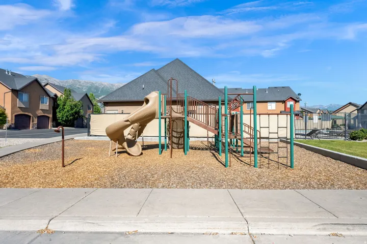 Community playground featuring a slide, climbing structures, and wood chip surfacing
