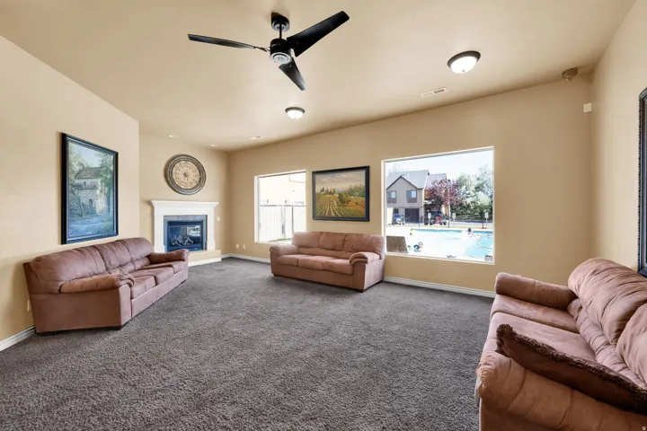 Club House-Spacious room featuring carpeting, a corner fireplace with a white mantel, and multiple windows offering external views