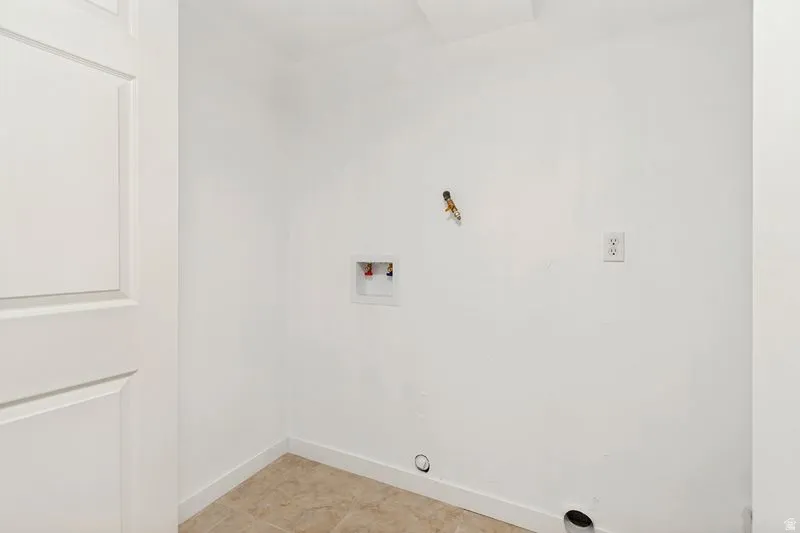 Laundry area featuring white walls, tile flooring, and utility hookups