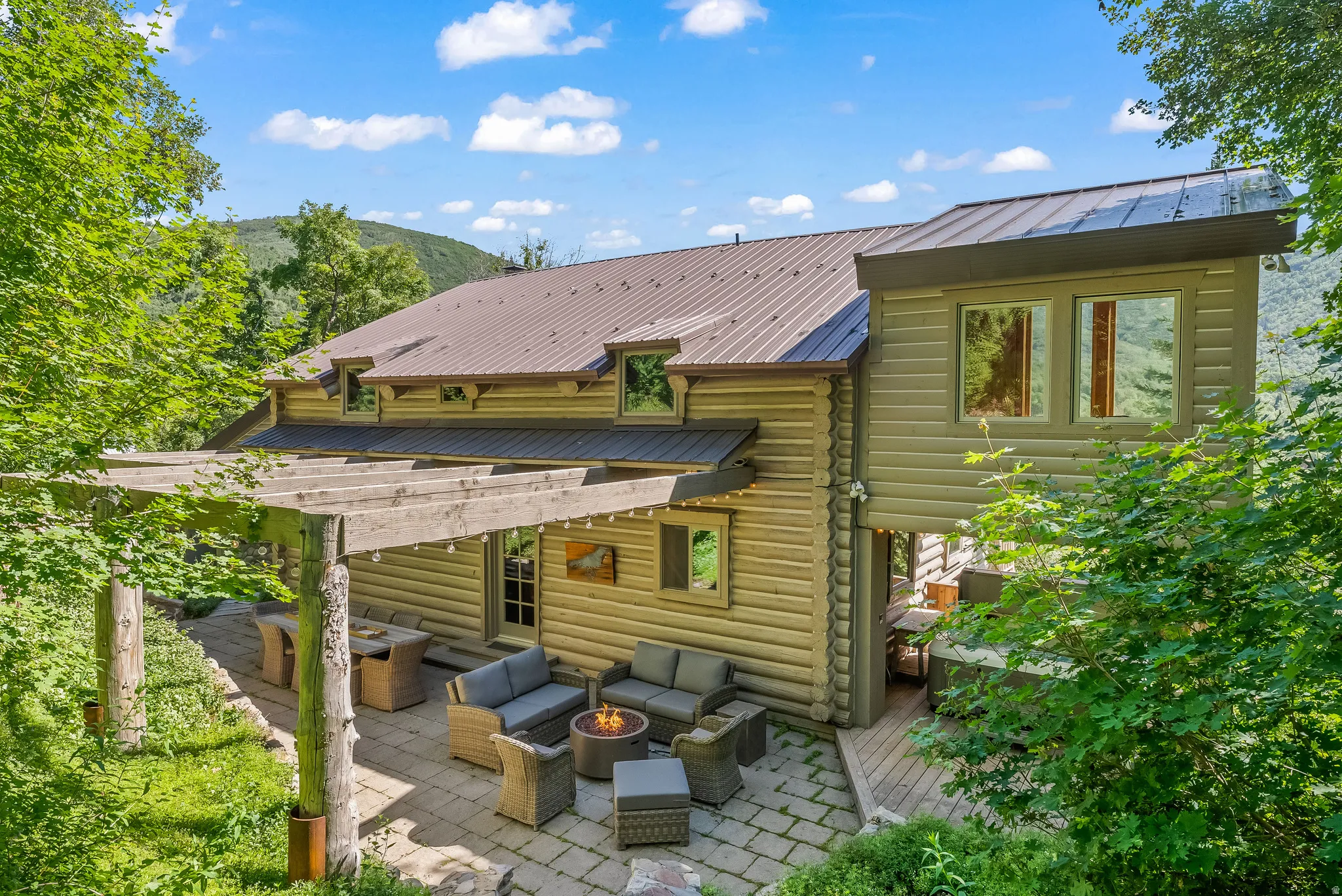 Expansive outdoor patio featuring a stone paver surface and a substantial wooden pergola