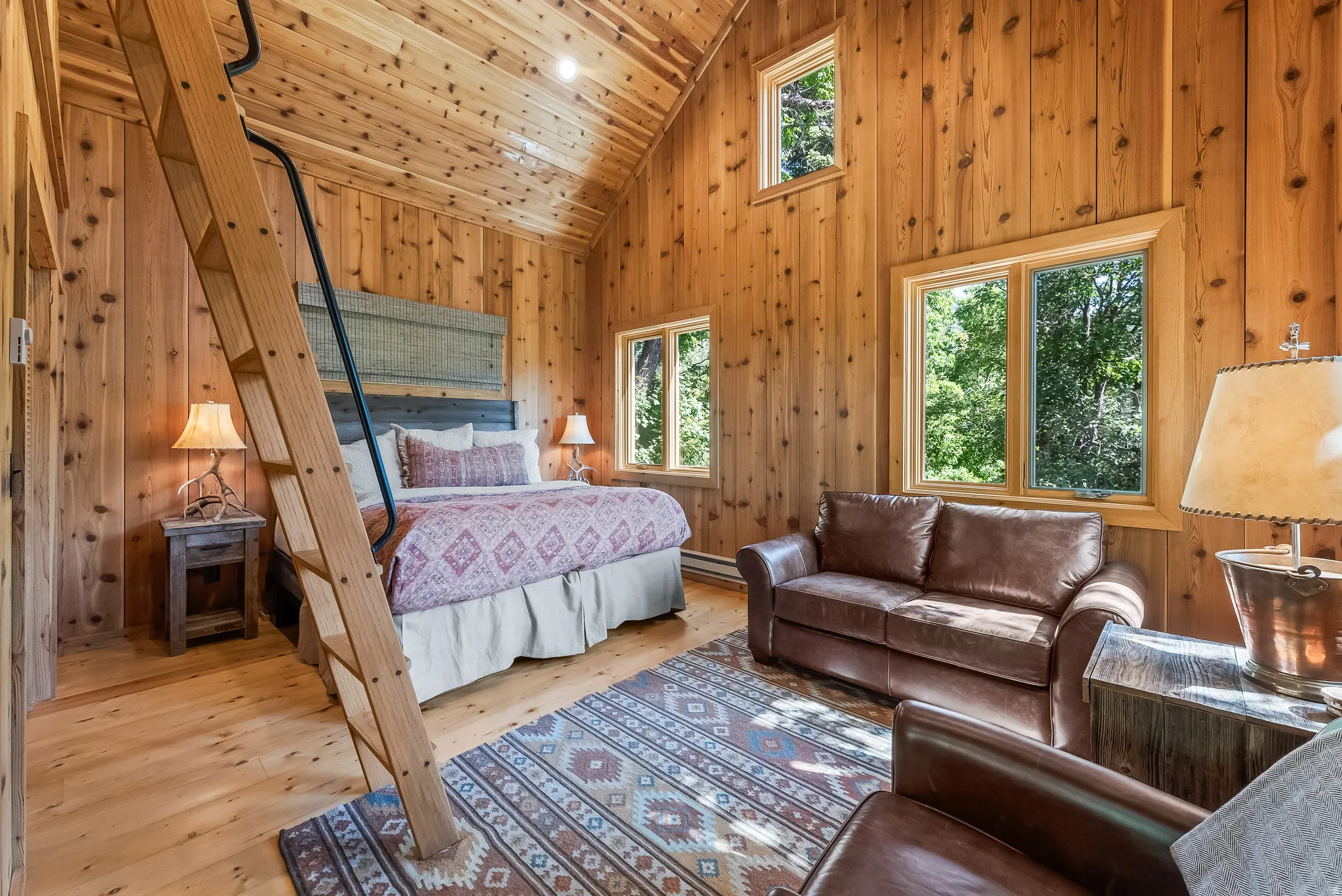 Vaulted wood-paneled ceiling, wood-plank flooring, and multiple windows