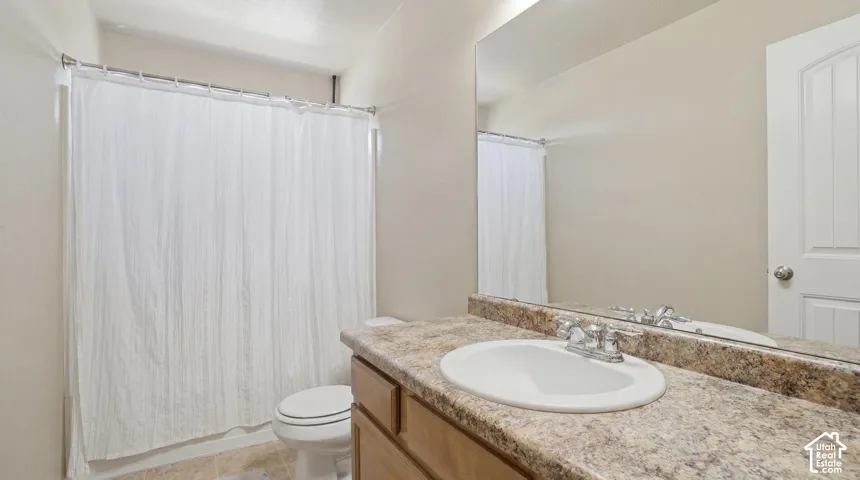 Bathroom featuring a vanity with a laminate countertop, an undermount sink, and a chrome faucet