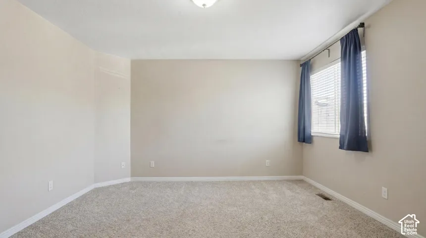 Neutral-toned walls and plush carpeting define this spacious room