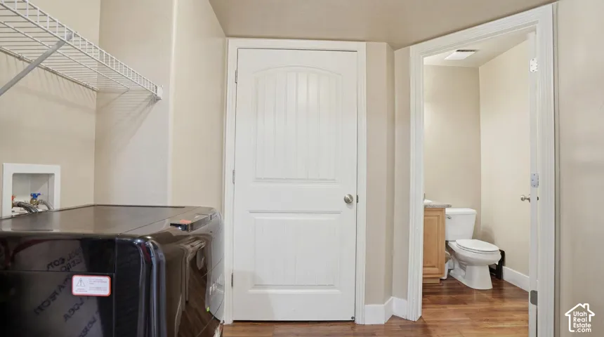 Dedicated laundry area featuring a wire storage shelf and utility hookups