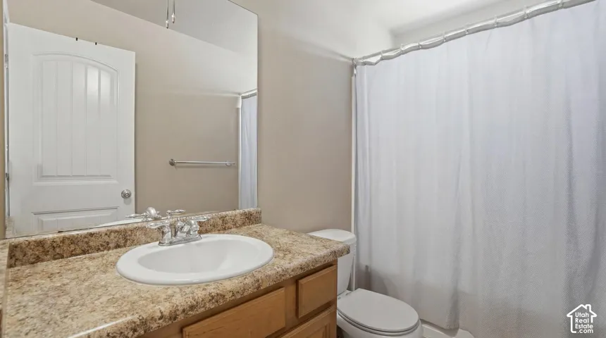 Bathroom featuring a spacious vanity with a speckled countertop and integrated sink